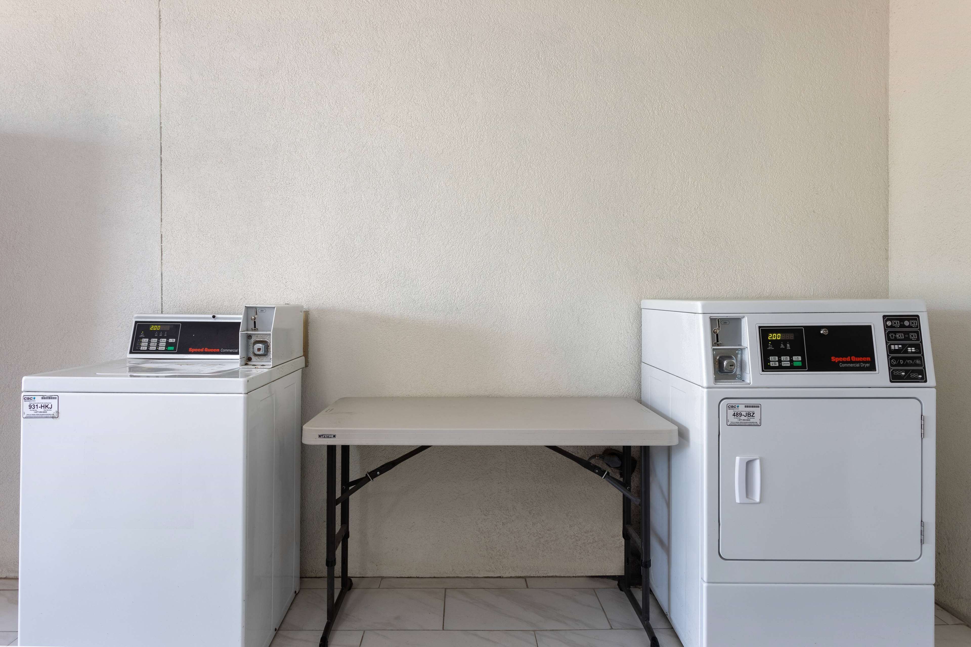 A laundry area with two washing machines and a drying rack.