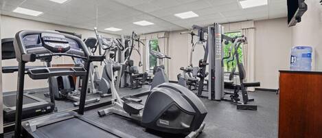 A gym with treadmills, elliptical machines, and weight equipment.