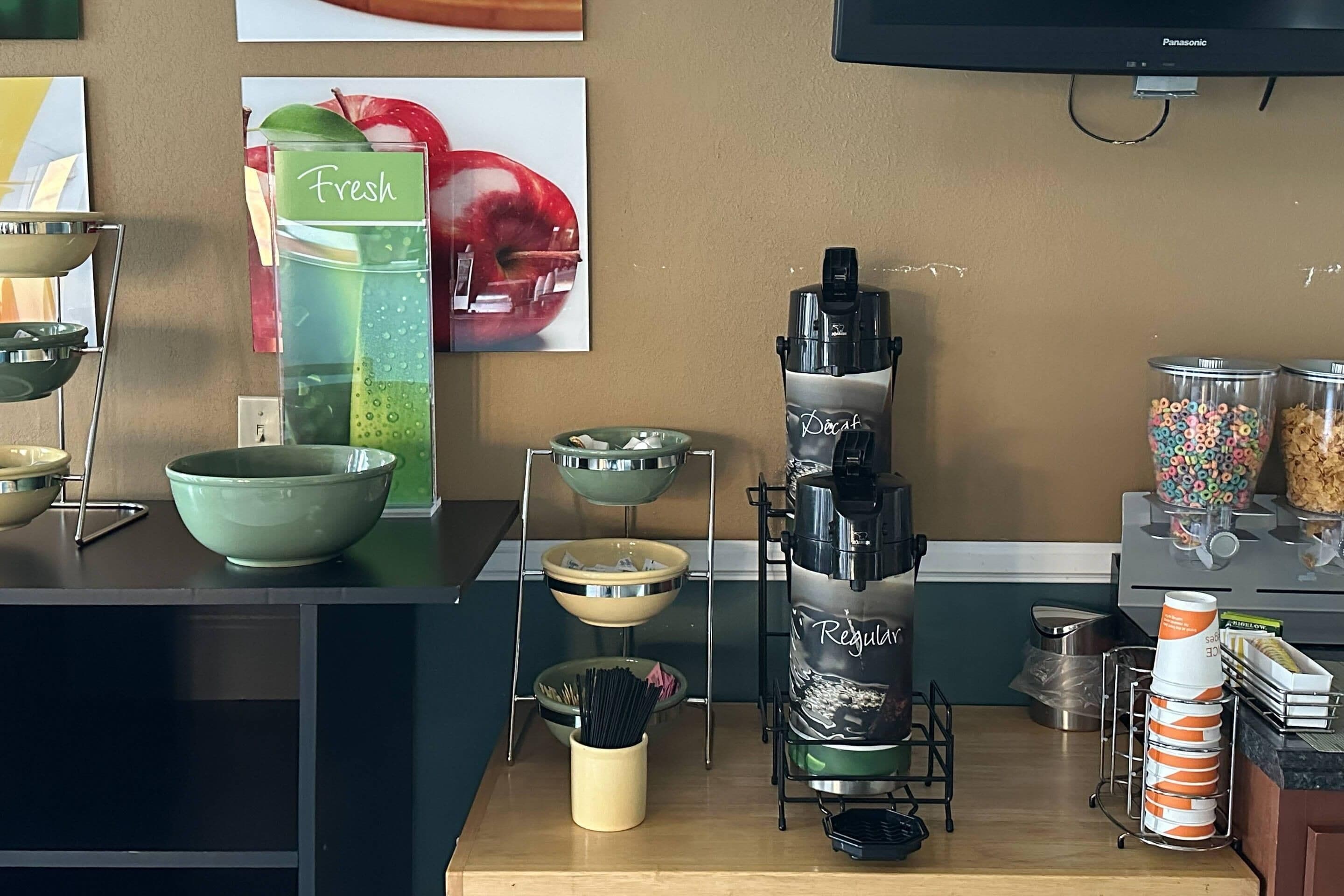 Una cuina amb diferents electrodomèstics i recipients, com ara una batedora, bols i una cafetera.