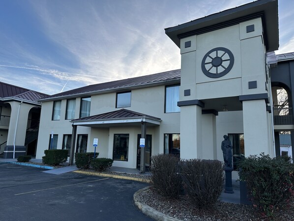 A building with a clock tower, a statue, and a parking lot. - Quality Inn Ashland (Ashland)