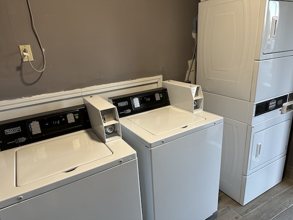 Une buanderie équipée de deux machines à laver à chargement frontal et d’un sèche-linge superposé.