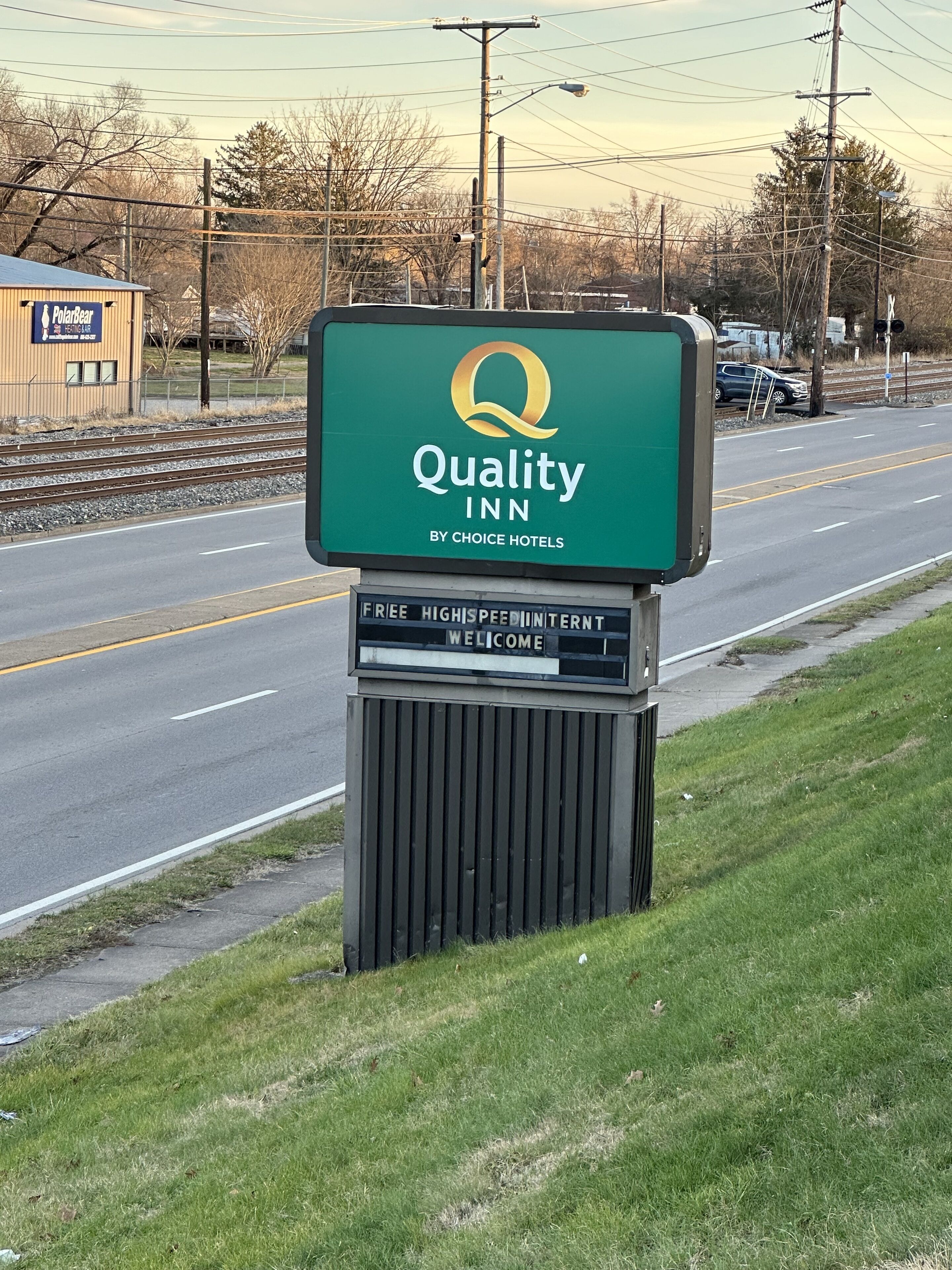 A Quality Inn sign by Choice Hotels with a green background and a yellow logo.