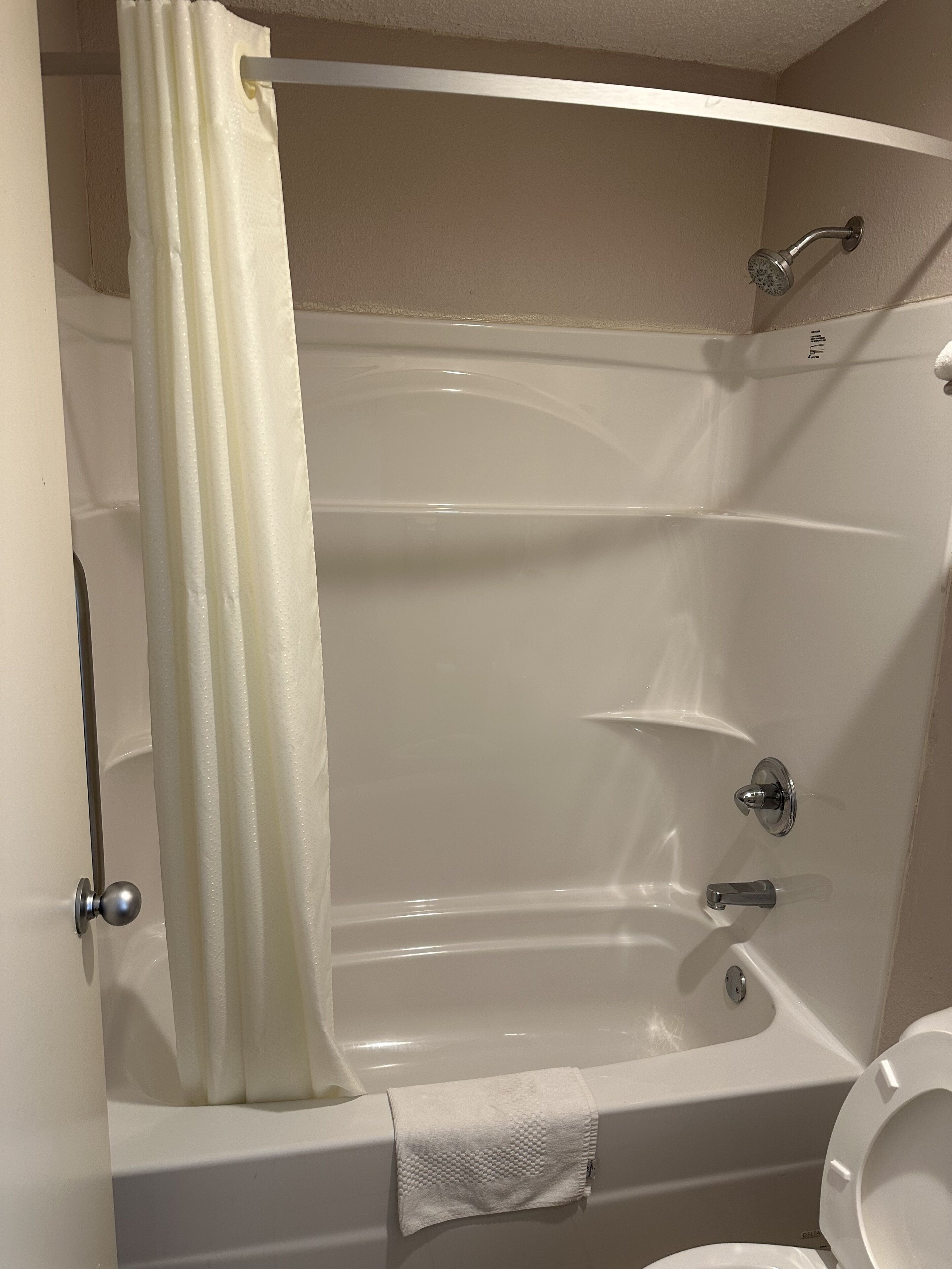 Un baño con bañera, inodoro y cortina de ducha.