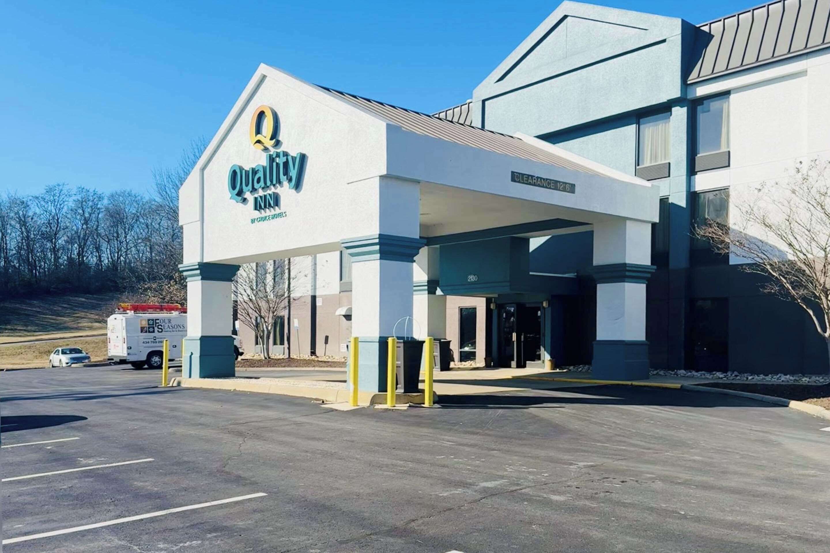 A Quality Inn with a clear entrance, a parking lot, and a building with a modern design.
