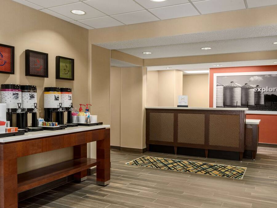 A reception area with a coffee station, a reception desk, and a wall with framed artwork.