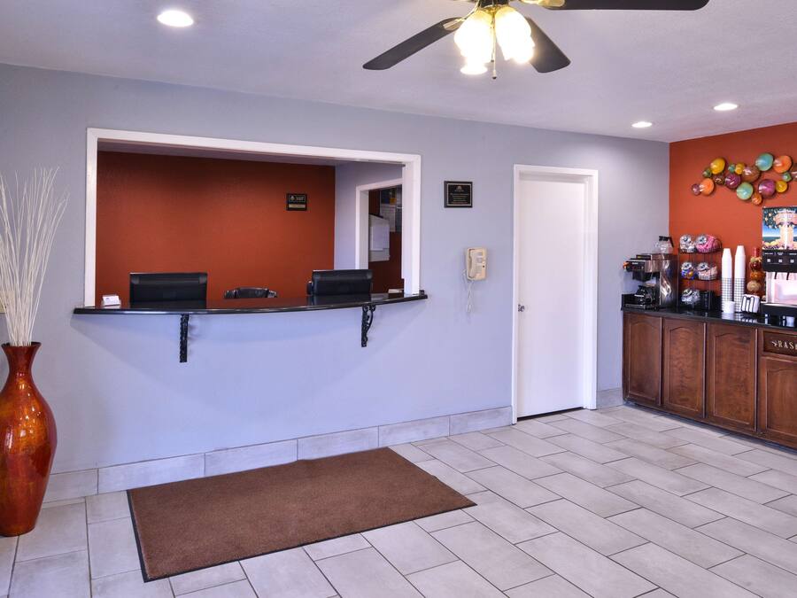 A reception area with a counter, a phone, a trash bin, and a ceiling fan.