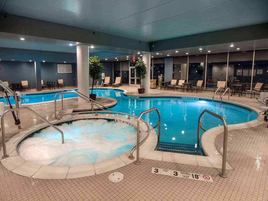 Una piscina interior amb diverses lànies, gandules i una zona de banyera d'hidromassatge.