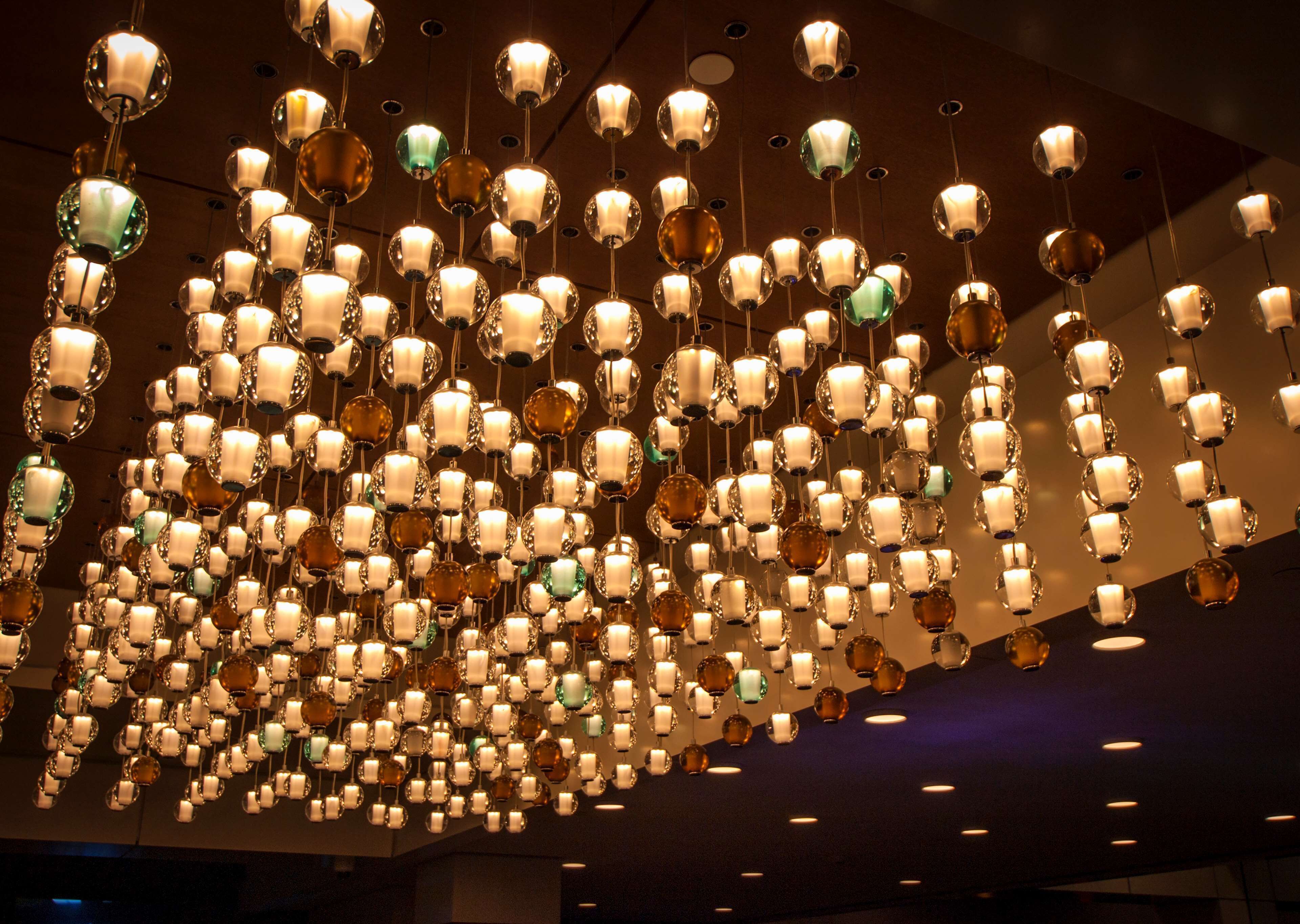 A ceiling with numerous hanging spherical light fixtures.