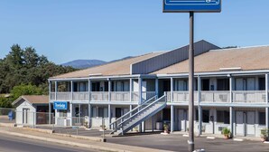 Un motel Travelodge de dos pisos, con una escalera central y vistas despejadas del paisaje circundante.