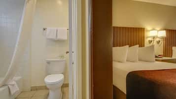 A hotel room with a bathroom including a toilet, a shower, and a bathtub.