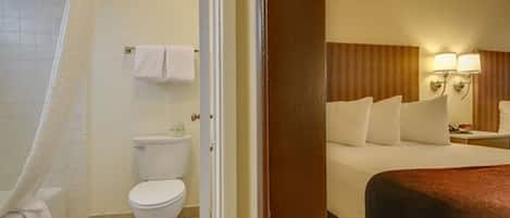 A hotel room with a bathroom including a toilet, a shower, and a bathtub.