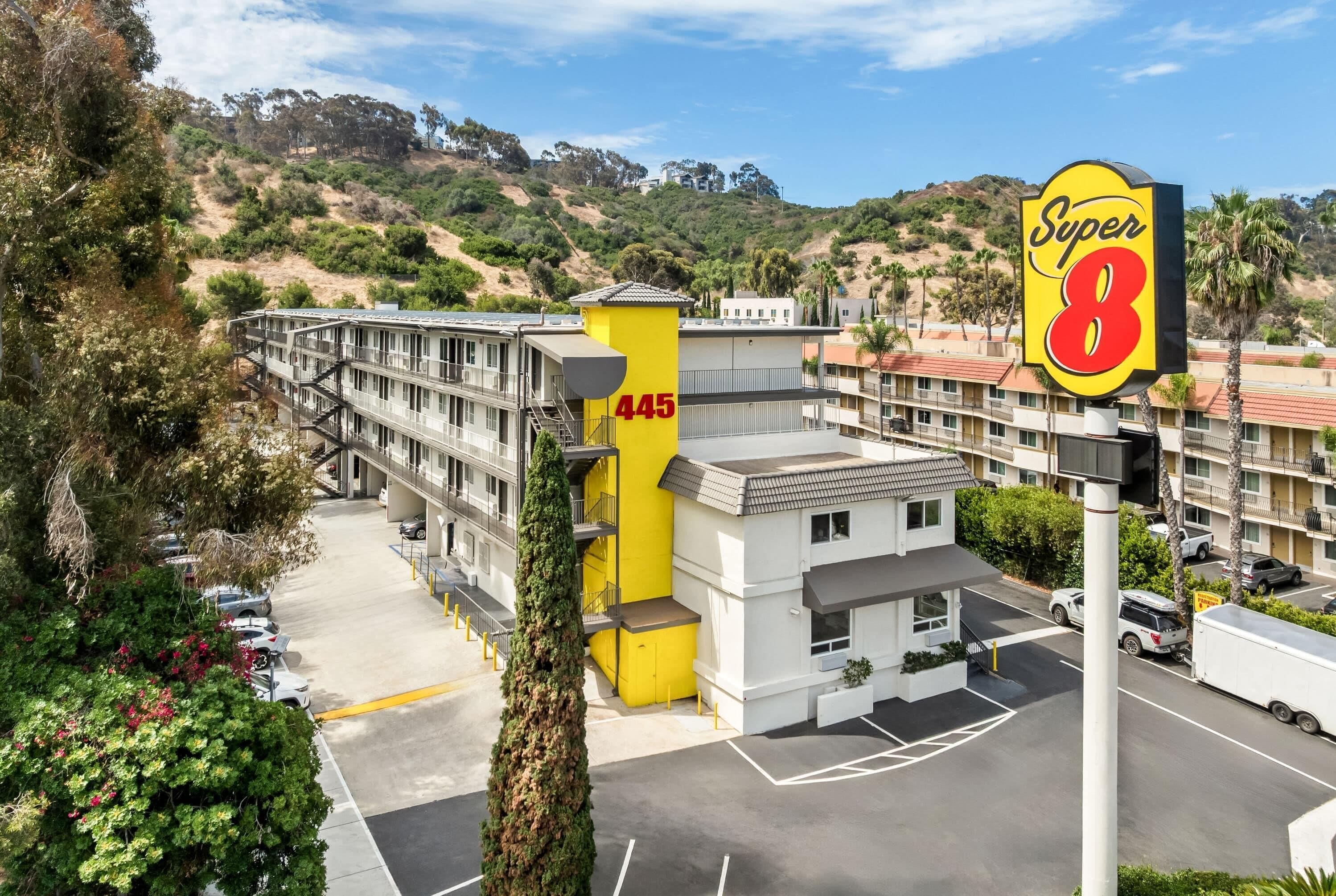 Un motel reconnaissable à son bâtiment jaune distinctif, portant le numéro 445, et arborant une enseigne Super 8.