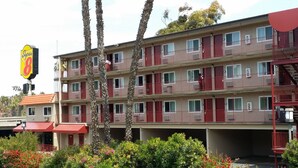 A multi-story motel with red balconies and a Super 8 sign. - Super 8 by Wyndham San Diego Hotel Circle (San Diego)