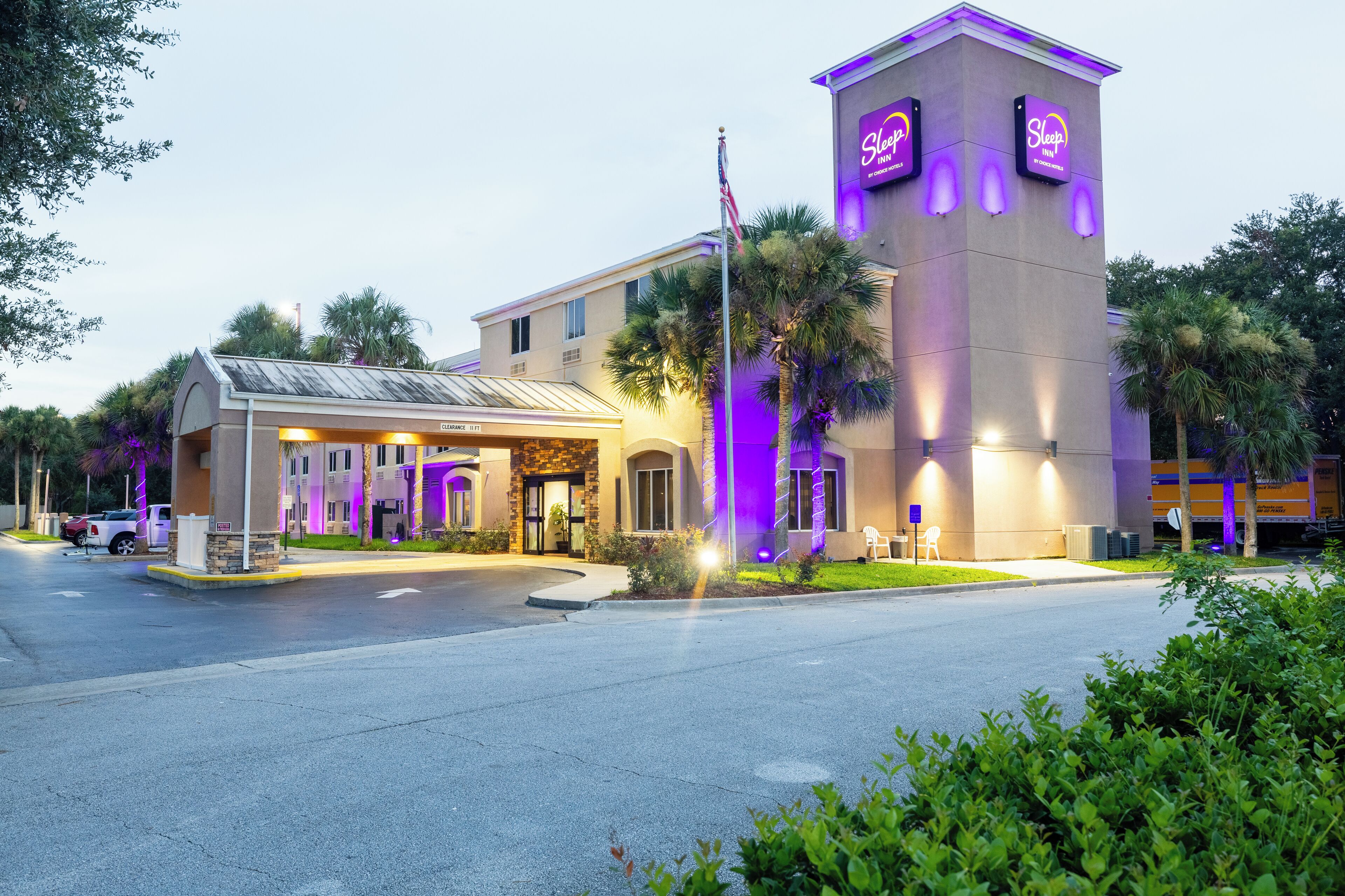 A hotel with a prominent tower and a covered entrance.