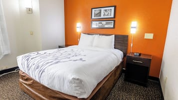 Habitación de hotel con cama, dos mesitas de noche y una lámpara de pared.