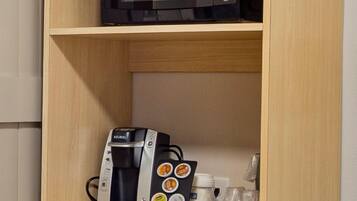 A kitchenette with a microwave, coffee maker, and a small refrigerator.