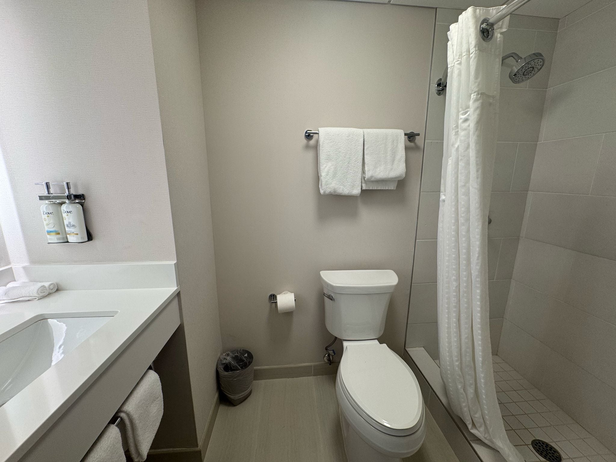 A bathroom with a toilet, a shower, and a sink.