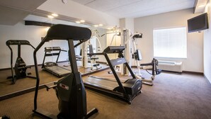 Un gimnàs amb cintes de córrer, el·líptiques i equips de musculació.
