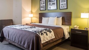 Habitació d'hotel amb un llit, dues làmpades de nit, una tauleta de nit i una cadira.