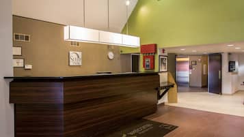 A reception desk with a clock, framed awards, and a "Sleep Inn" sign.