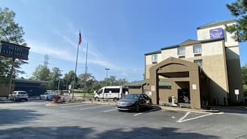 A Sleep Inn hotel with a parking lot, a flagpole with an American flag, and a sign for Ruby Tuesday.