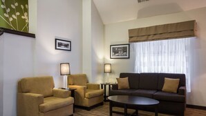 Habitació d'hotel amb un sofà, dues butaques, una taula de centre i dues làmpades.