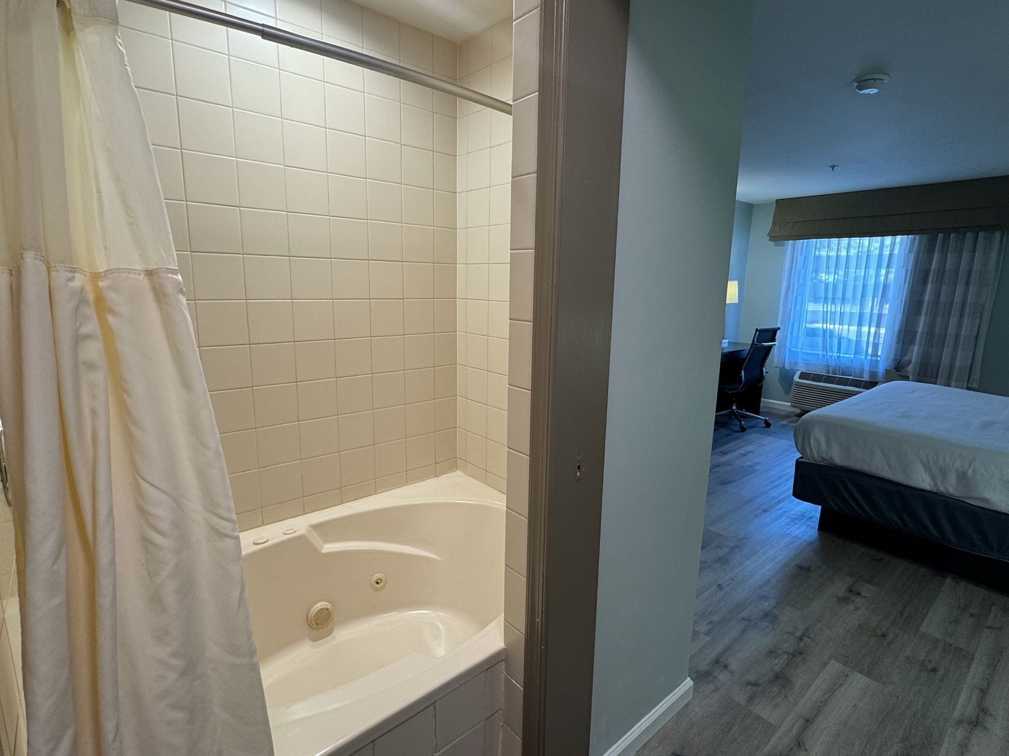 Ein Badezimmer mit Badewanne, gefliesten Wänden und einer Duschvorhang.
