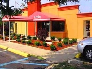 A building with a red awning labeled "Lobby" and a parking area with a car. - A Victory Inn - Roseville (Roseville)