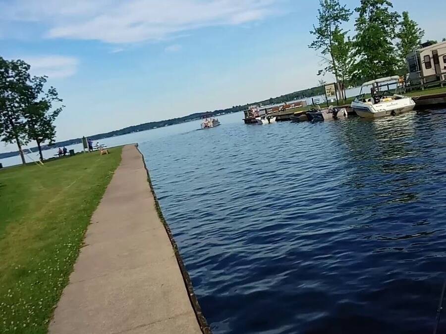 Une zone riveraine dotée d’une promenade en béton, de bateaux et d’un terrain de camping pour caravanes.