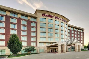 Stylish hotel with a symmetrical facade, featuring a covered entrance and multiple windows.