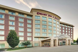 Stylish hotel with a symmetrical facade, featuring a covered entrance and multiple windows.