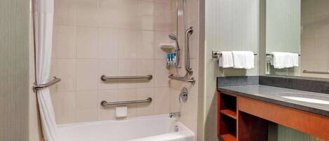 Un baño moderno con bañera, ducha y tocador con espejo.