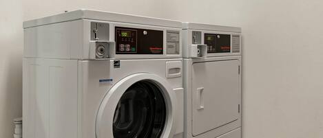 Un appareil combiné lave-linge et sèche-linge à chargement frontal, de type superposé, doté d’écrans numériques et de panneaux de commande.