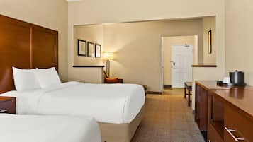 Una habitación de hotel con una cama grande, un escritorio, una silla y una lámpara.