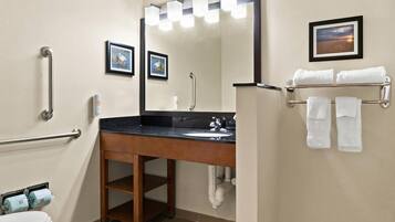 Une salle de bain équipée d’un lavabo, d’un miroir et d’un porte-serviettes.