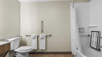 A bathroom with a toilet, a shower with a curtain, and a towel rack with towels.