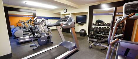 A gym with treadmills, elliptical machines, and a weight rack.
