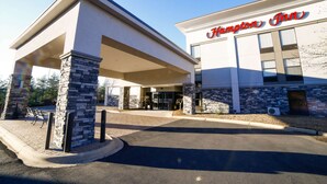 A Hampton Inn building with a stone facade and a covered entrance area.