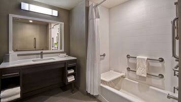 Un baño moderno con ducha, lavabo y tocador.