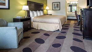 A hotel room with a bed, two bedside tables, a desk, a chair, a television, and a mirror. - Quality Inn Greenwood Hwy 25 (Greenwood)