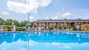 A hotel with a swimming pool, outdoor seating, and a no lifeguard on duty sign. - Quality Inn Greenwood Hwy 25 (Greenwood)