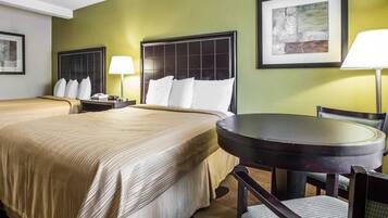 Een hotelkamer met twee bedden, een ronde tafel en een stoel.