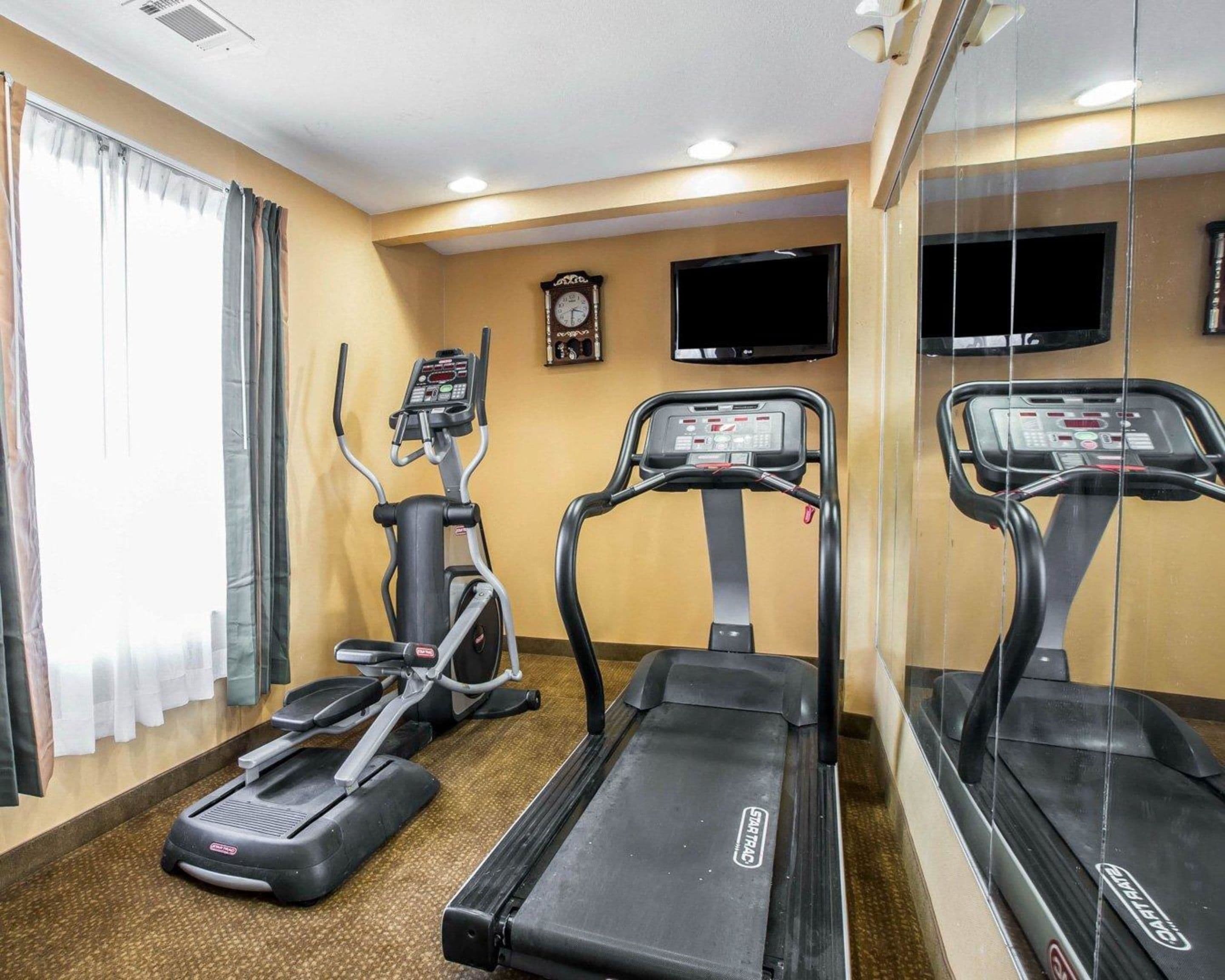 A fitness room with treadmills, an elliptical, and a stationary bike.