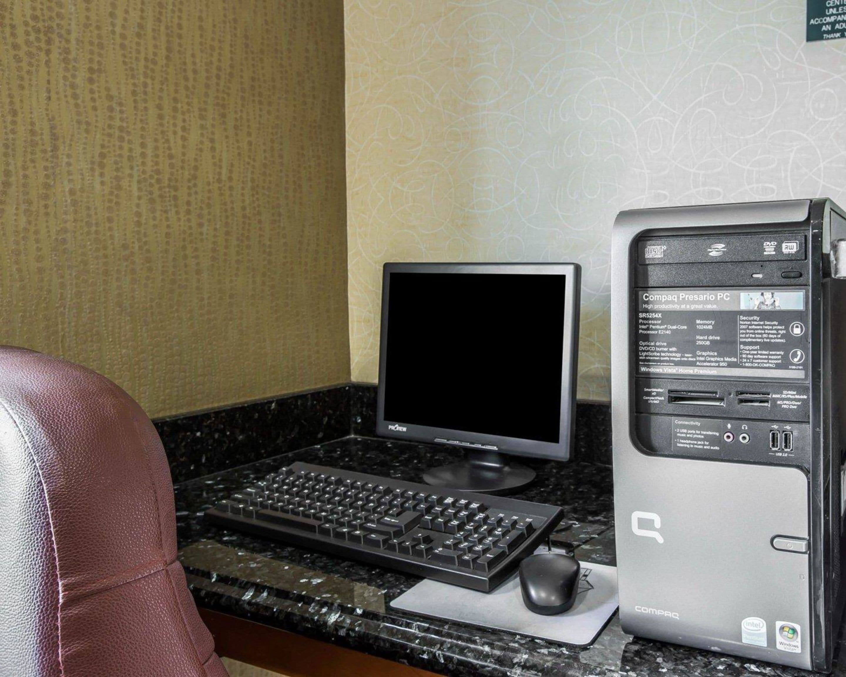 A desktop computer with a monitor, keyboard, and mouse on a marble countertop.