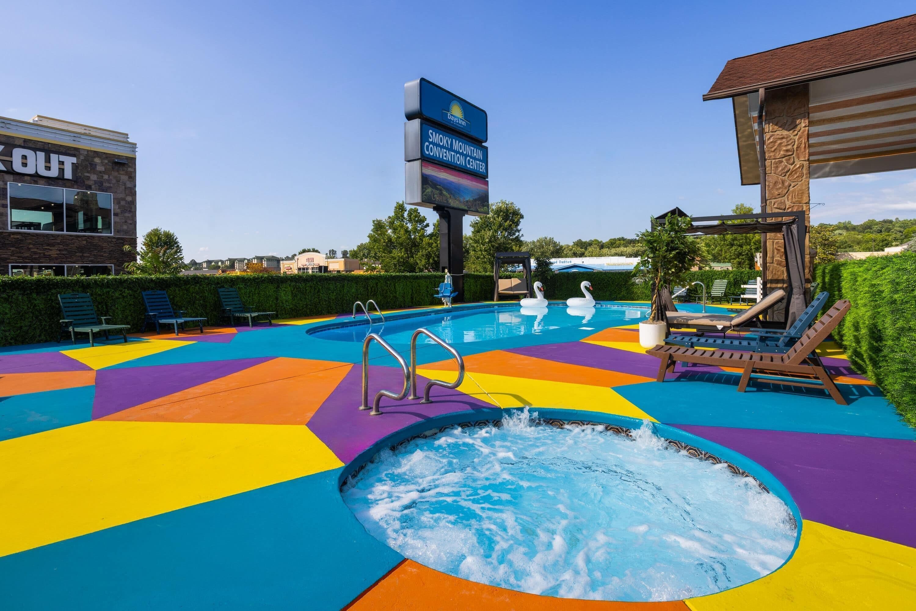 A pool area with a hot tub, lounge chairs, and a sign for the Smoky Mountain Convention Center.
