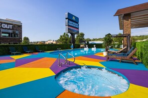 Zona de piscina con jacuzzi, sillas de descanso y un cartel del Centro de Convenciones Smoky Mountain.