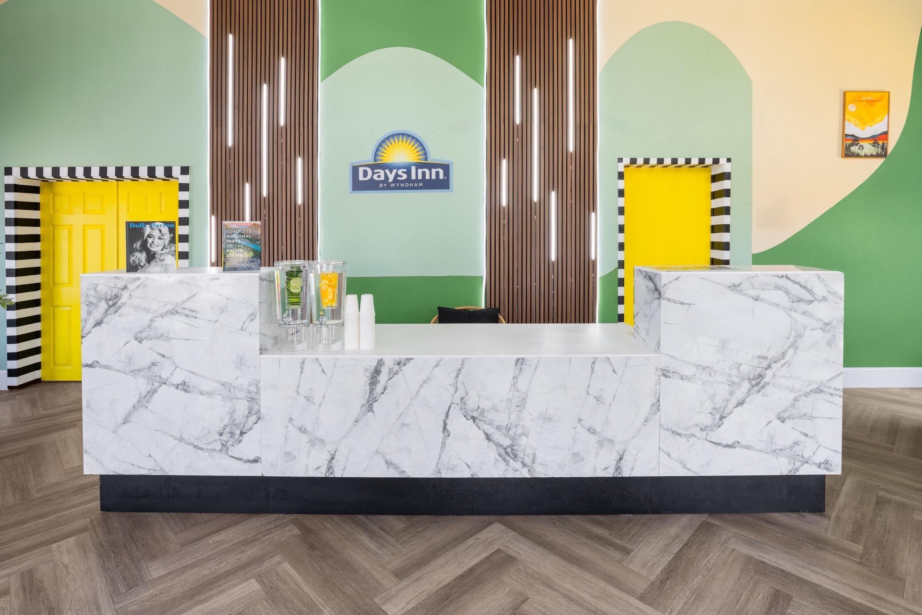 A reception desk with a marble top, a Days Inn sign, and a yellow door.