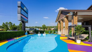 Una piscina con adornos de cisnes, una zona de estar cubierta y un letrero del Smoky Mountain Convention Center.