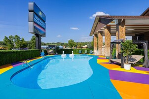 A swimming pool with swan decorations, a covered seating area, and a sign for Smoky Mountain Convention Center.