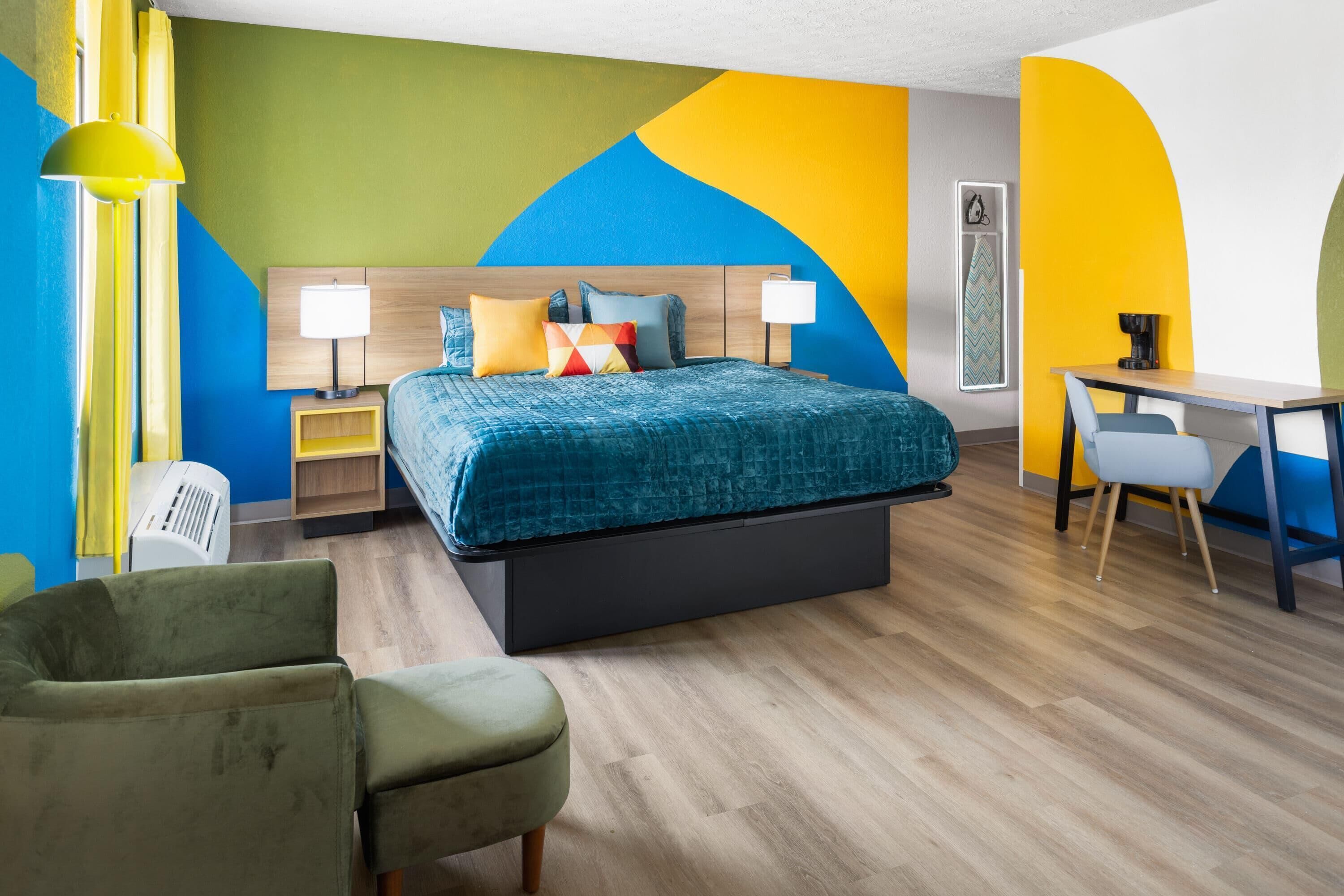 Una habitación de hotel con cama, mesitas de noche, escritorio y una silla.